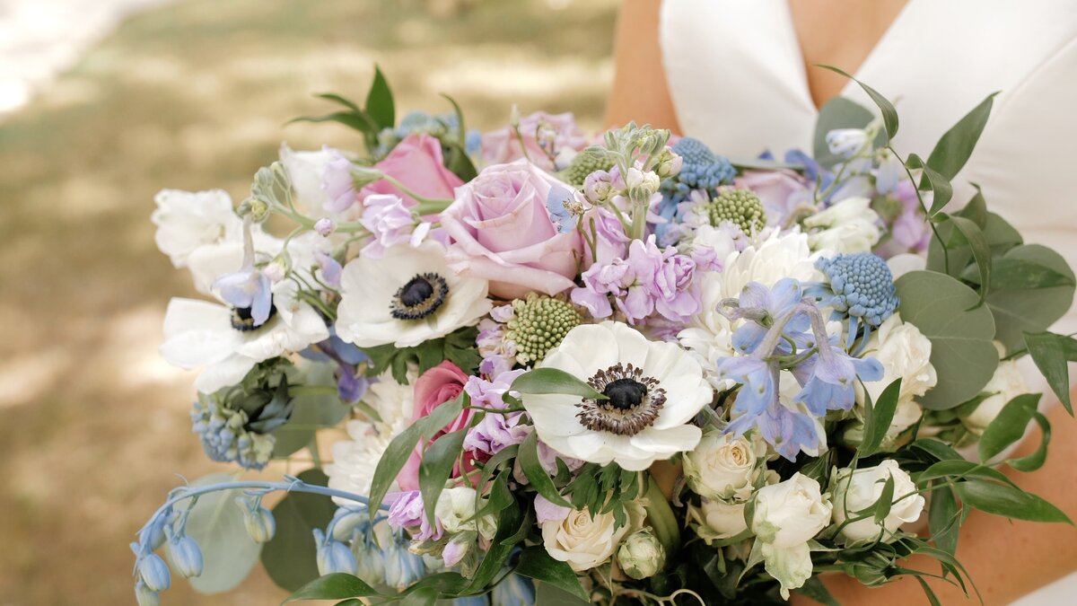 Bride holds pink and blue wedding bouquet