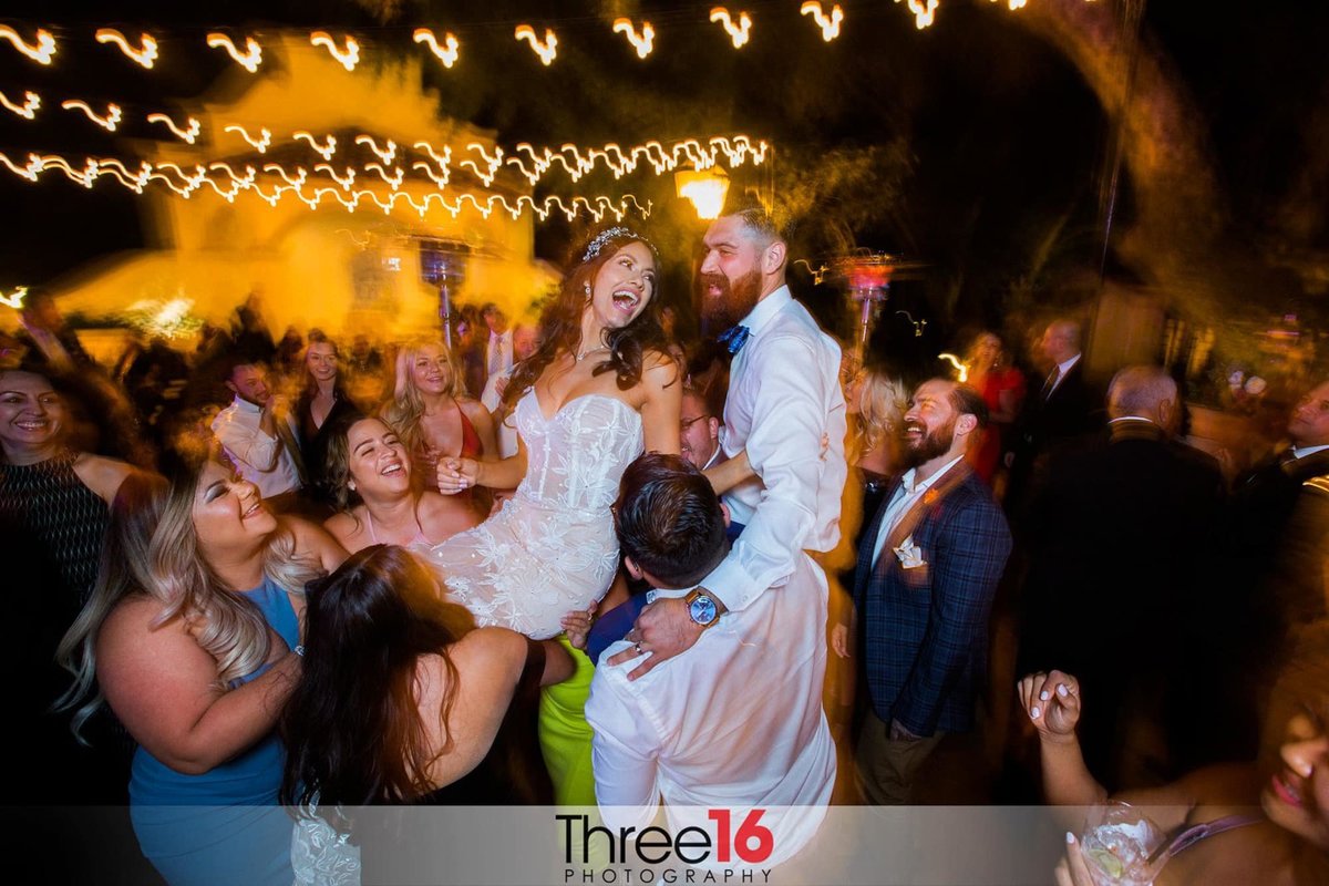 Guests lift the Bride and Groom into the air on the dance floor