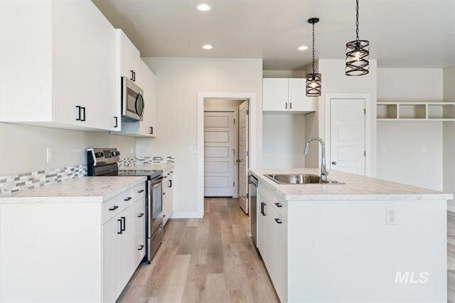 sleek modern kitchen with  white cabinets and white painted walls