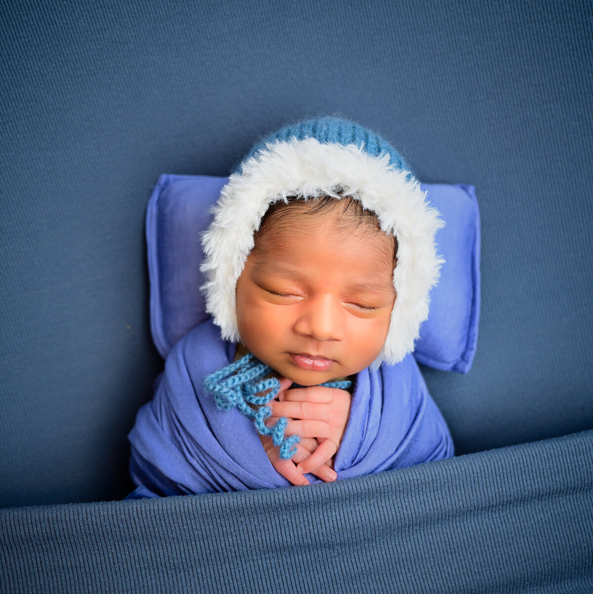 A newborn tucked in snuggly sleeping during his newborn session. Photographed by E. Benecki Photography of Kitsap County, WA