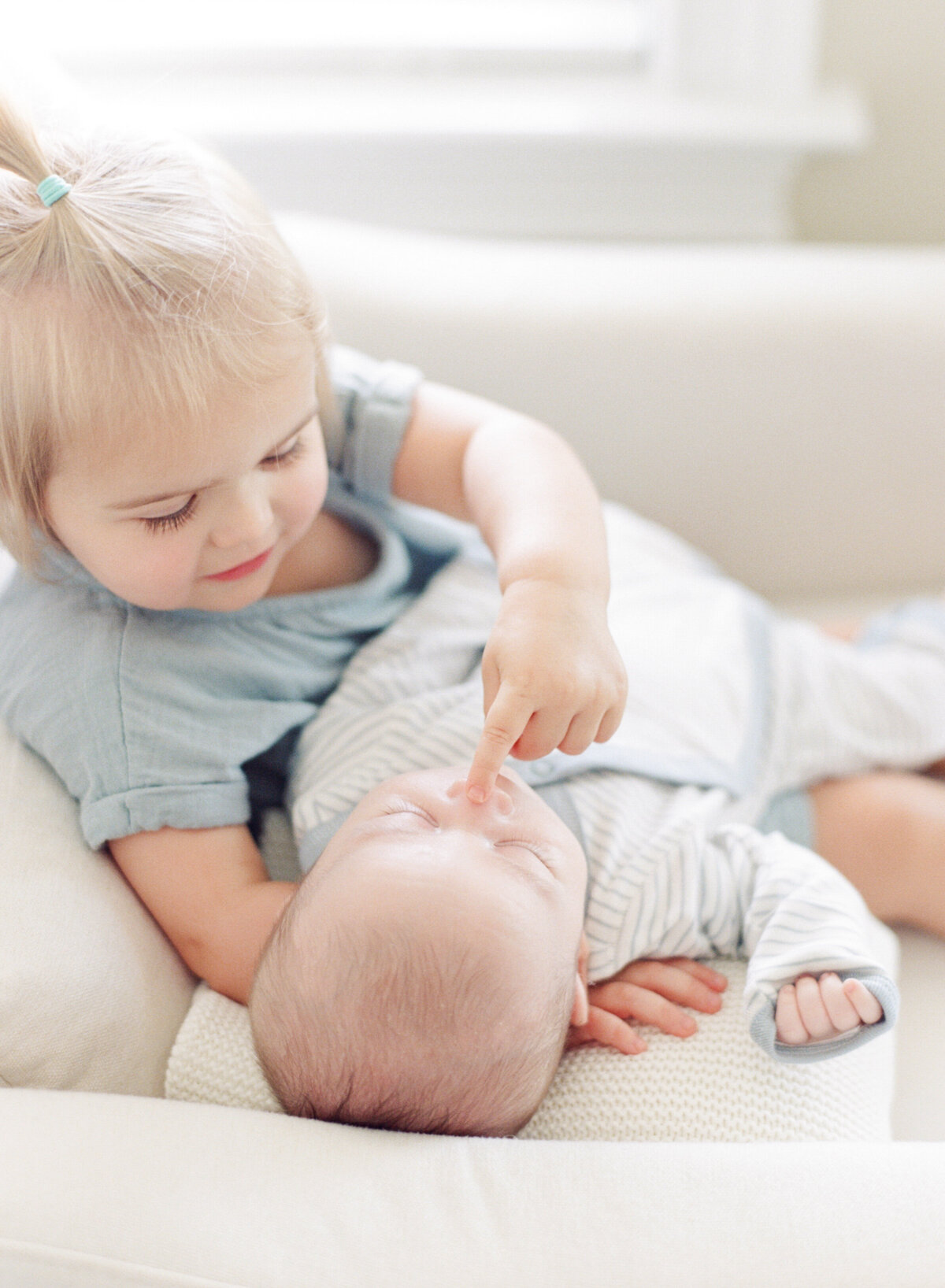 Big sister touches her baby brother's nose during an in home newborn session in Rolesville NC. Image by Raleigh newborn photographer A.J. Dunlap Photography.