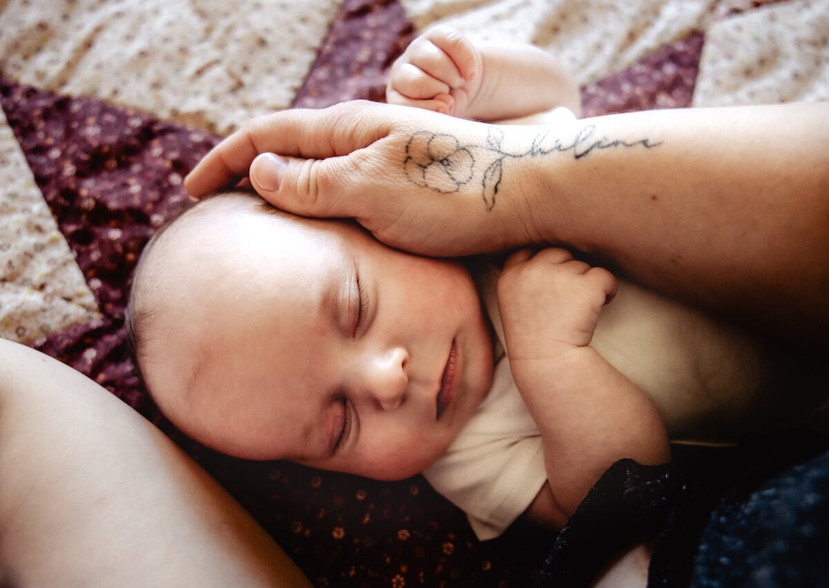 a newborn baby girl fast asleep next to her mom