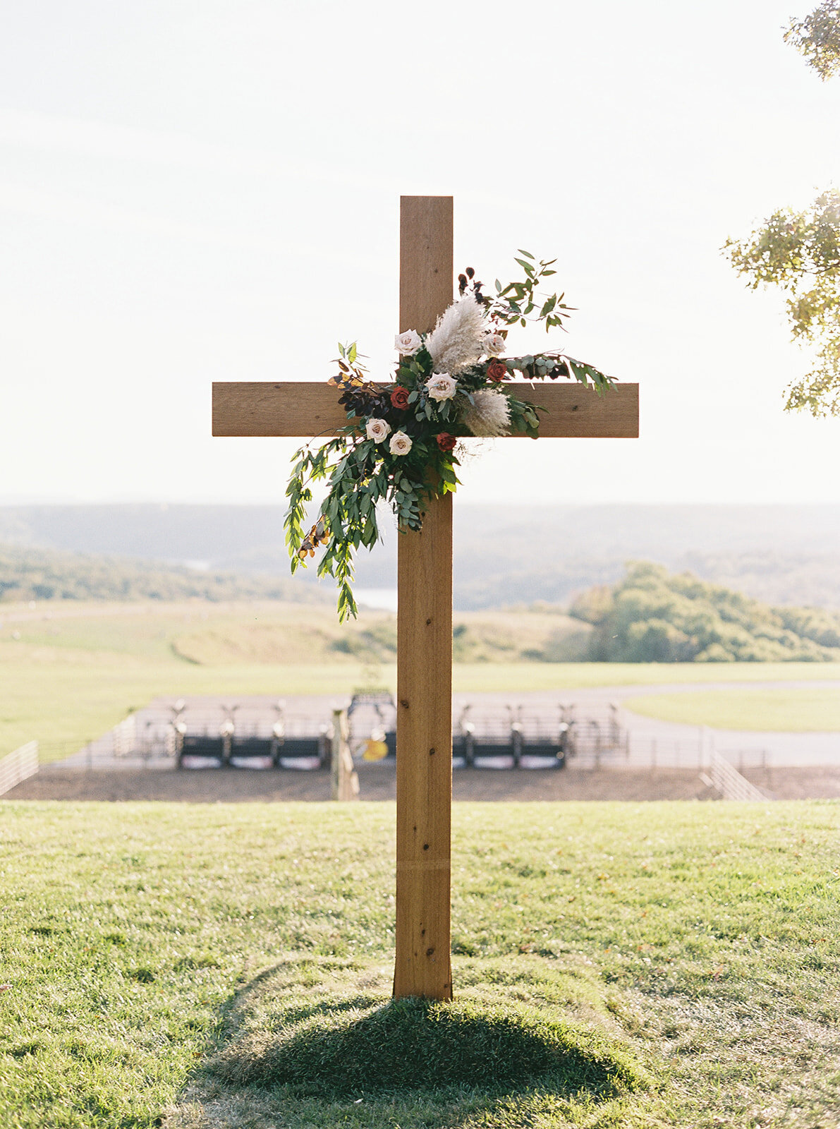 a cross with wedding reception tables in the background