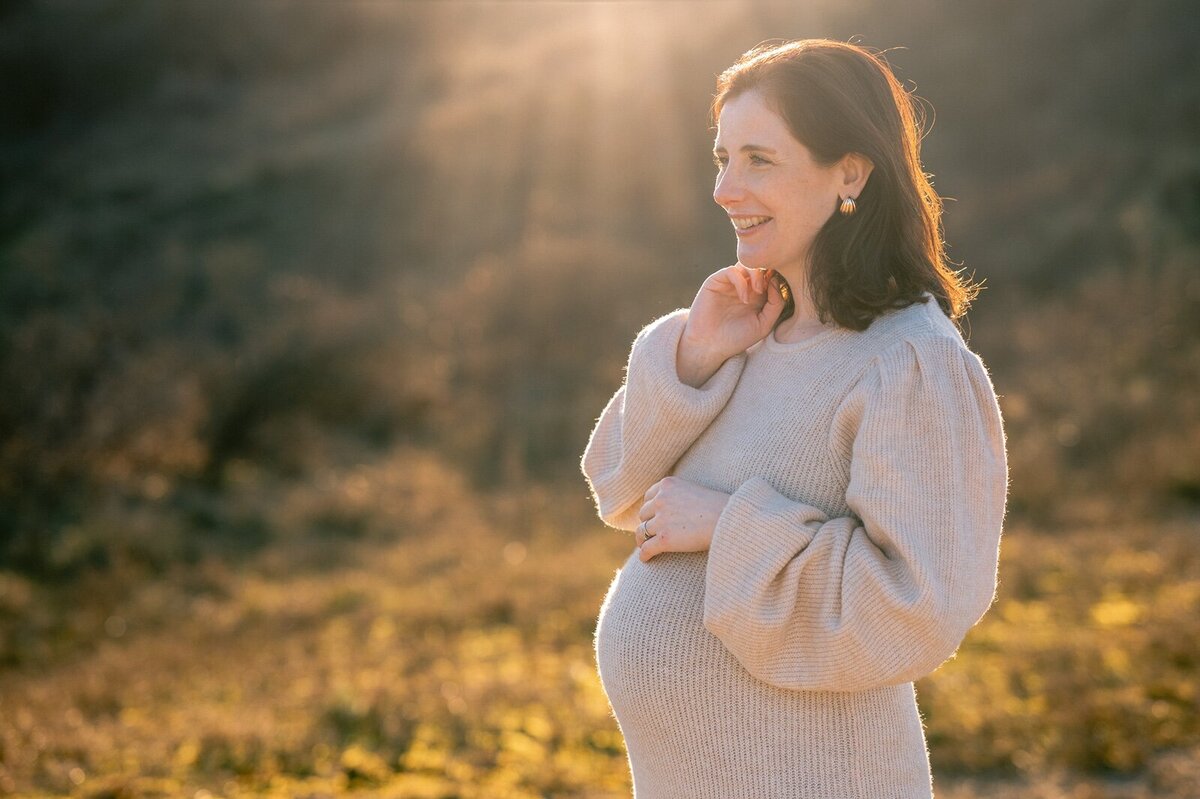 Zwangere vrouw in de duinen poseert voor Zwangerschapsshoot Leiden Fotograaf
