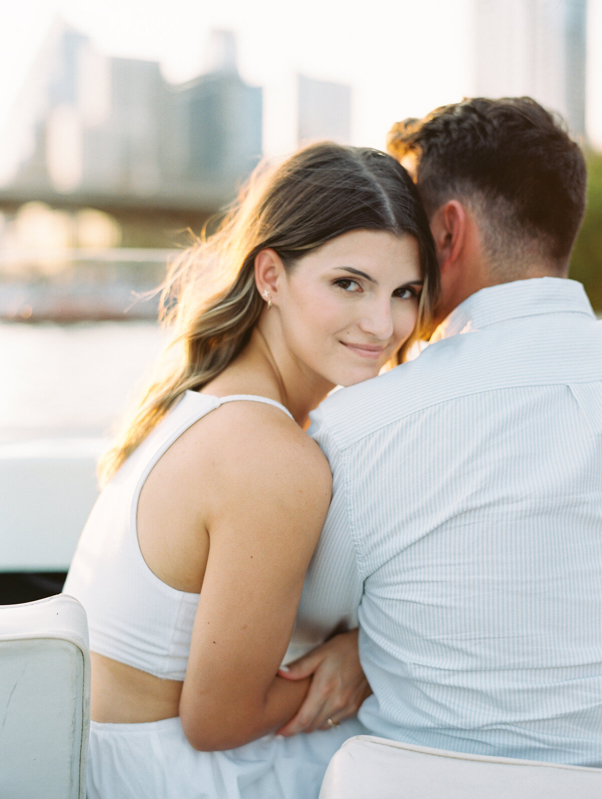 Woman smiling at the camera while leaning against man's shoulder