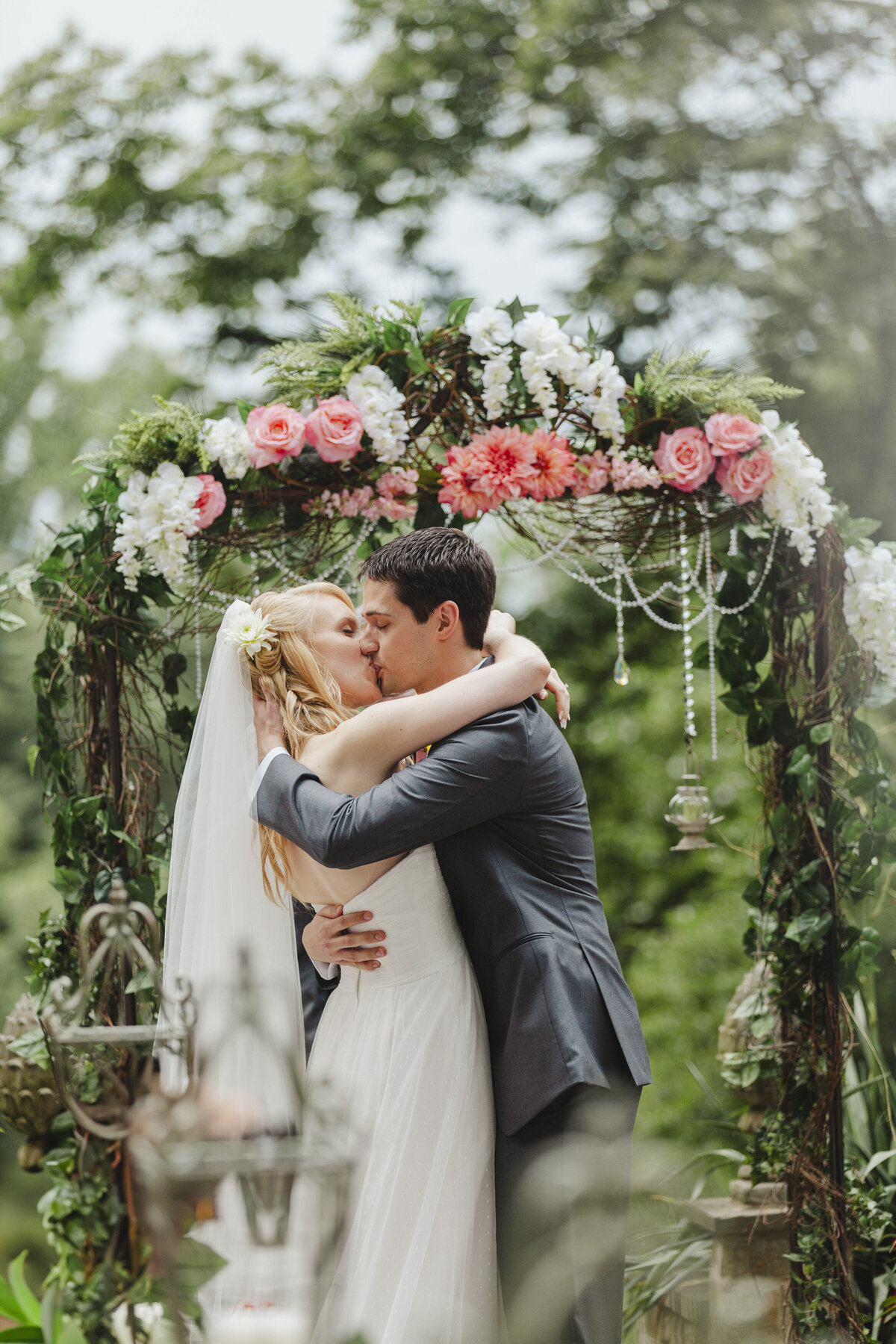 A newlywed couple kissing during their wedding ceremony 