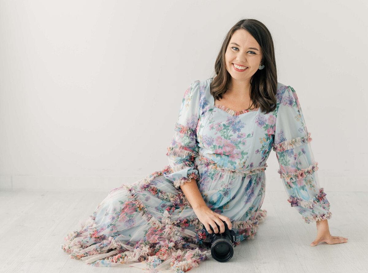 Wedding Photographer Educator Katiera sitting on ground smiling with camera