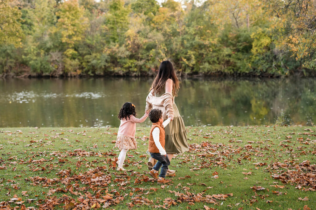 Mom running on grass with toddlers