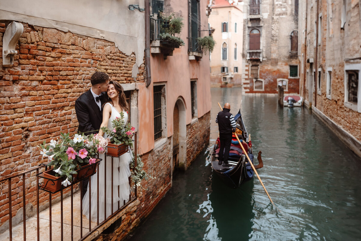 Bride and groom on balcony in Venice with Gondola