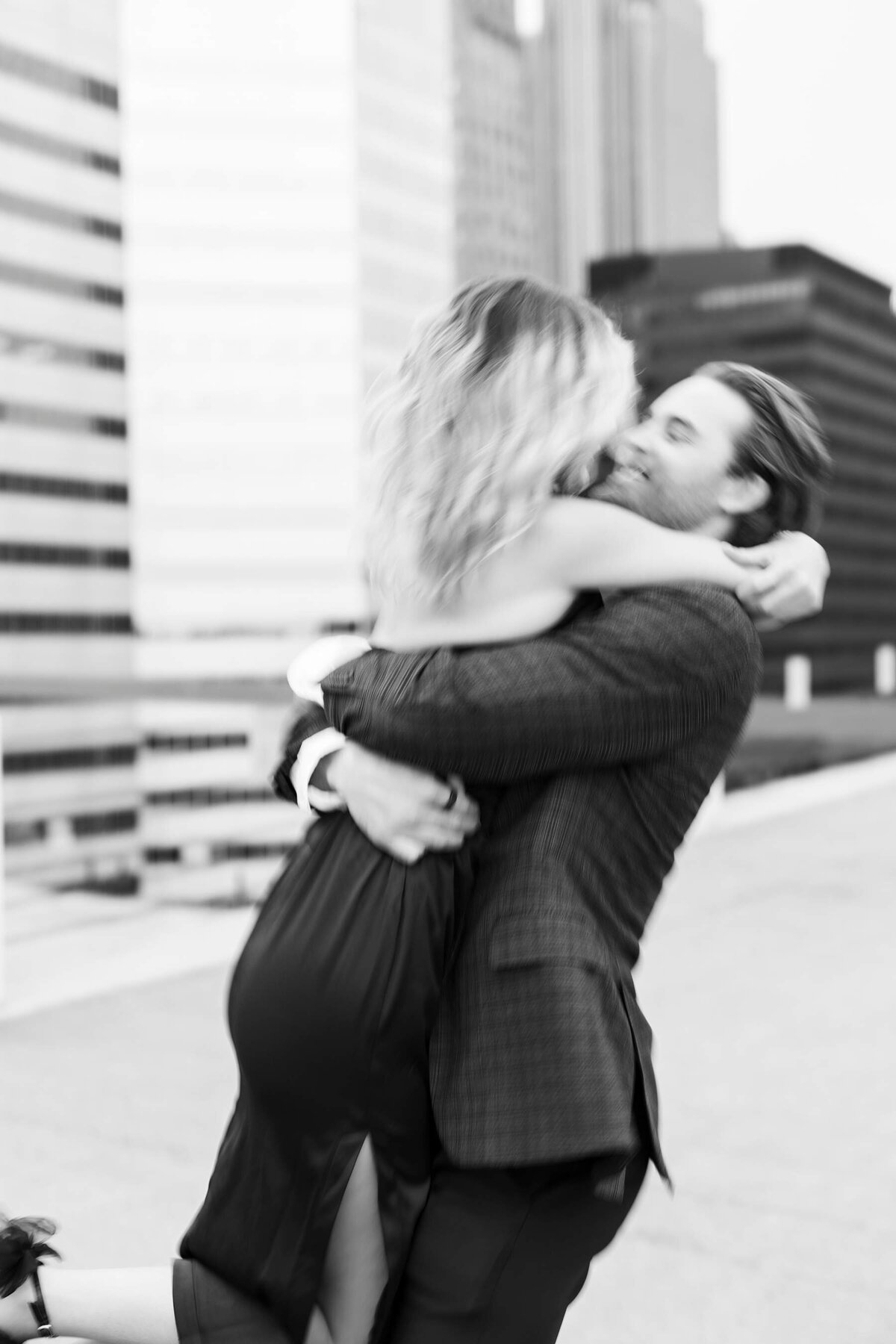 A sweet embrace unfolds during a Minneapolis engagement session in front of a striking urban mural, as the couple's love story is beautifully captured by Alexandra Robyn Photo + Design.