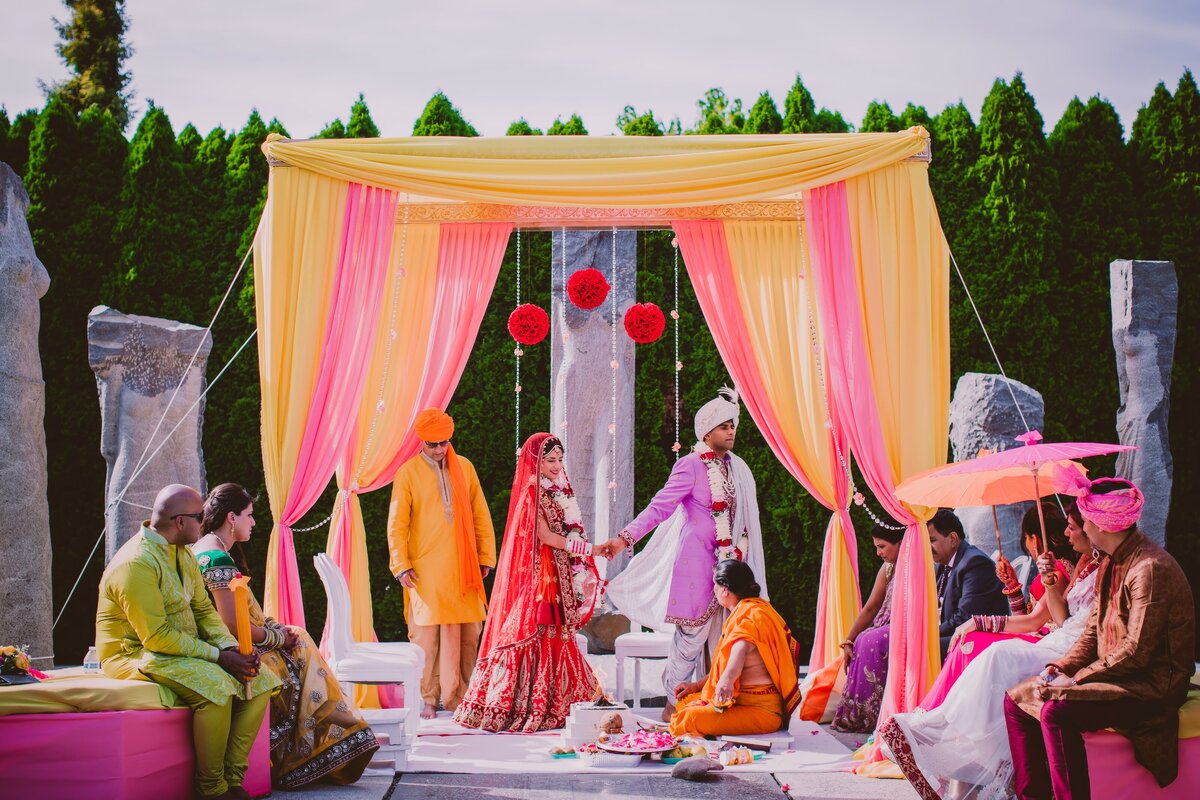 indian bride and groom walking around the fire during the hindu wedding ceremony at the grounds for sculpture in nj