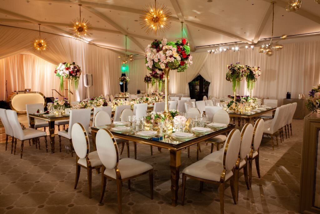 A wedding reception hall set up with white chairs