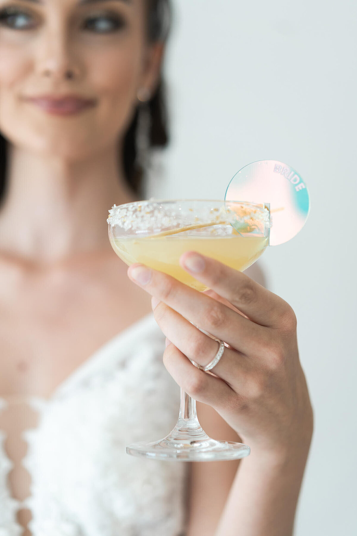 bride holds her signature drink at her wedding reception at The Homestead in Houston Texas