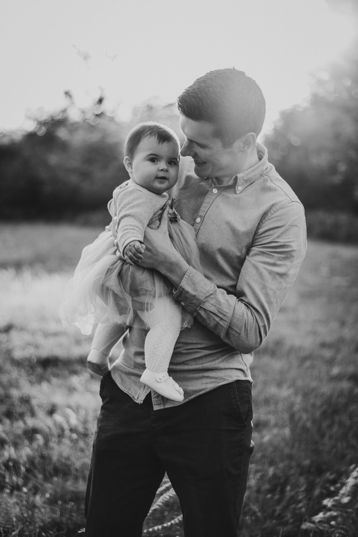 Black and white photo of man holding daughter