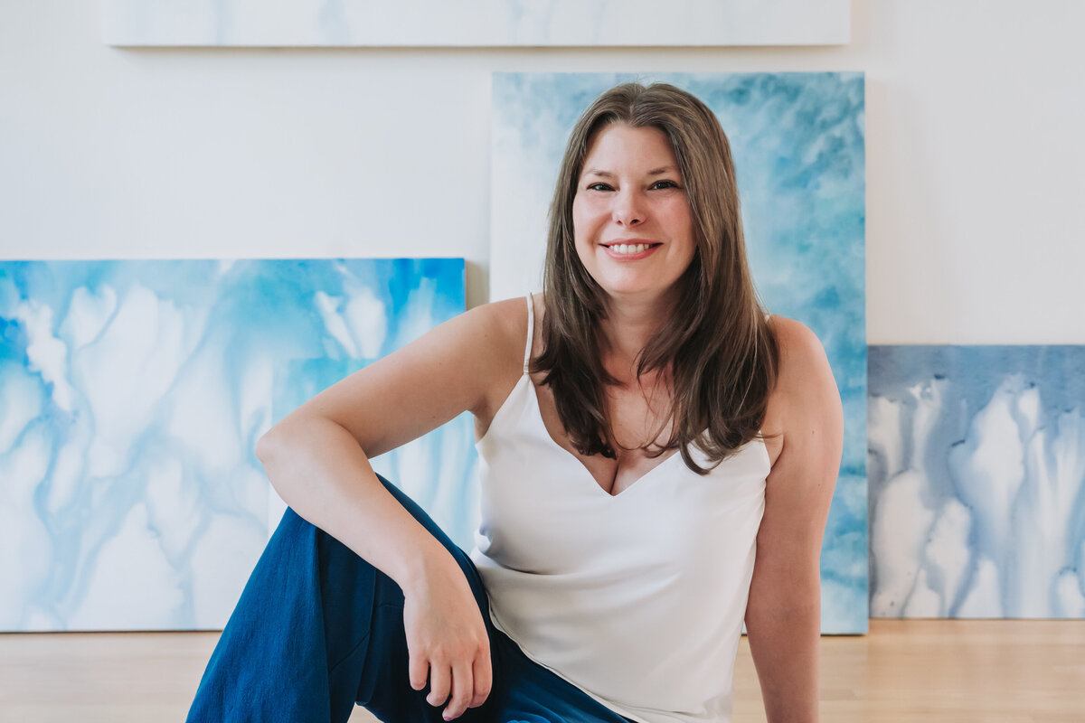 portrait of watercolor artist with paintings behind her