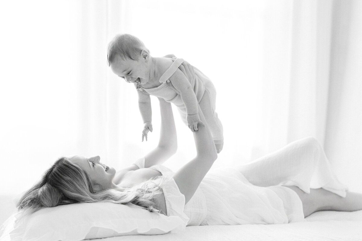 Tampa 6-month milestone portrait of smiling baby boy and mother in natural light studio