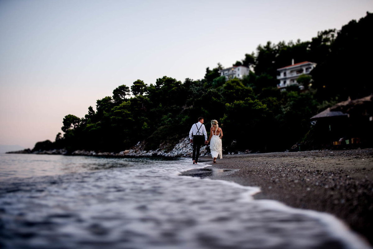 destination wedding photo of a bride and groom walking along a beach