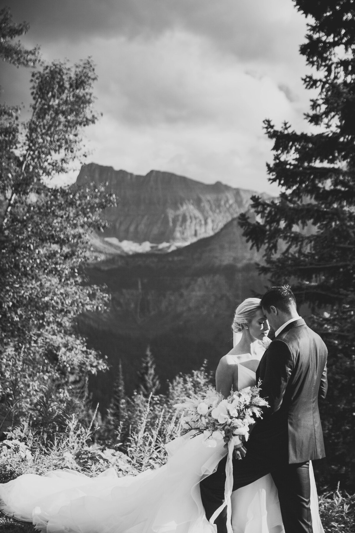 bride and groom standing by mountains