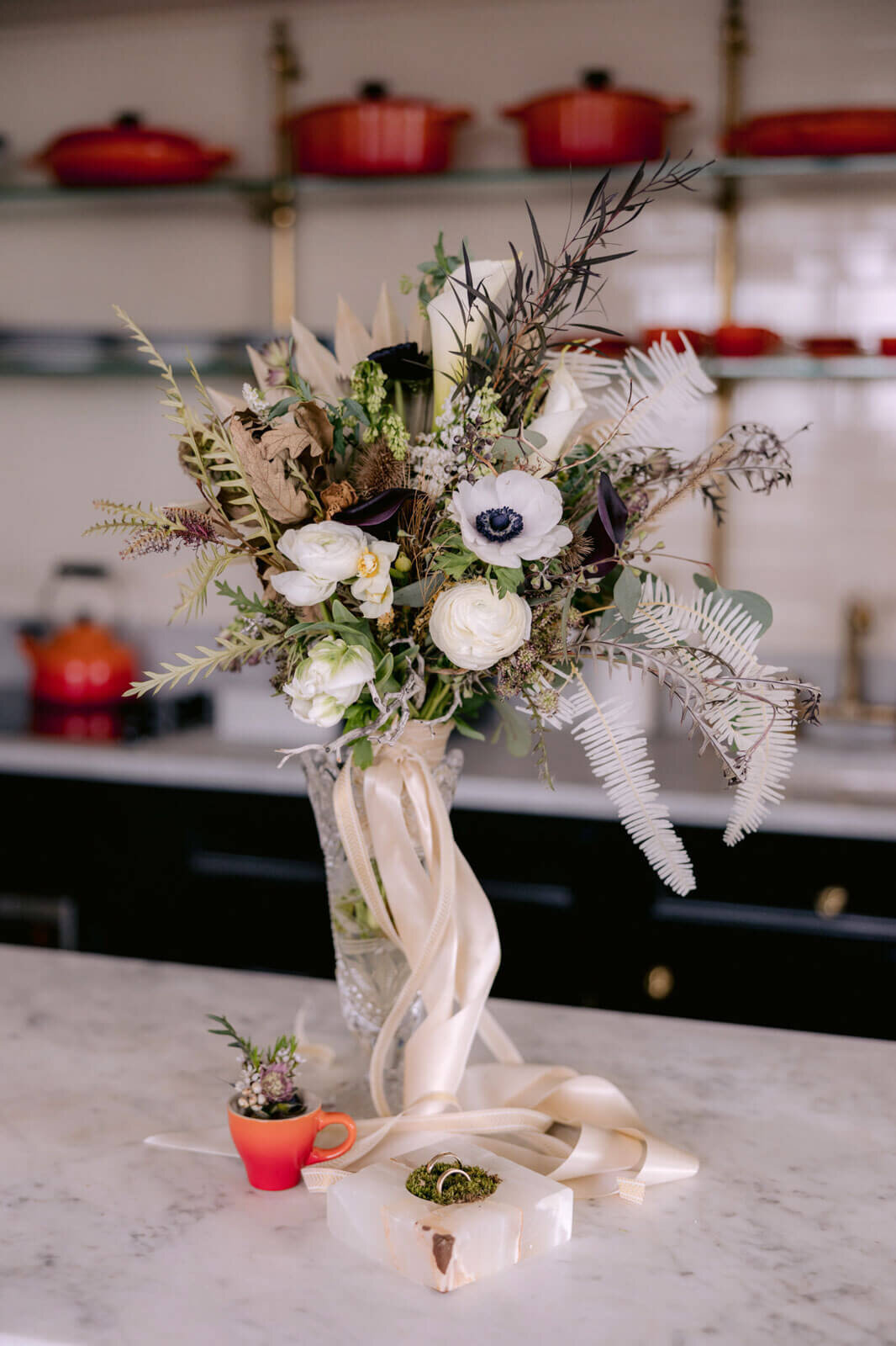 A bouquet of flowers in a glass vase on a kitchen countertop
