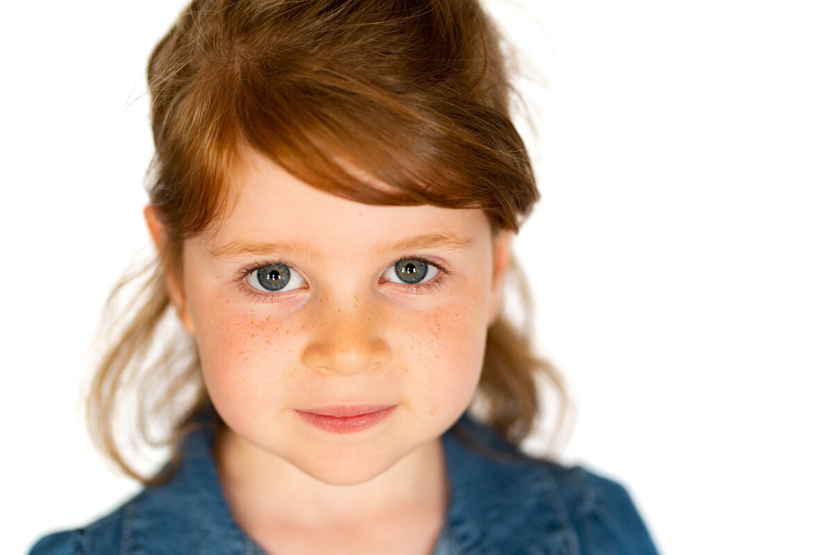 Little girl with red hair and blue eyes in school photo