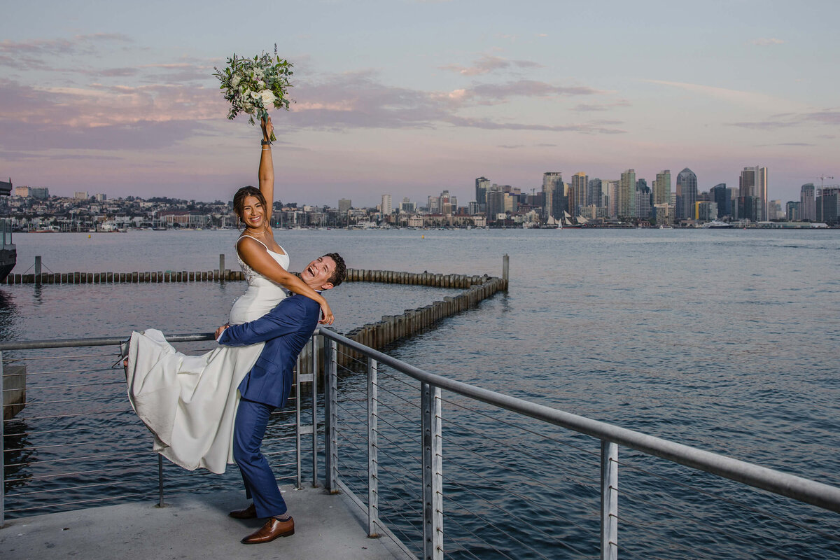 bride-and-groom-celebrating-at-coasterra-san-diego-wedding-venue-skyline-view