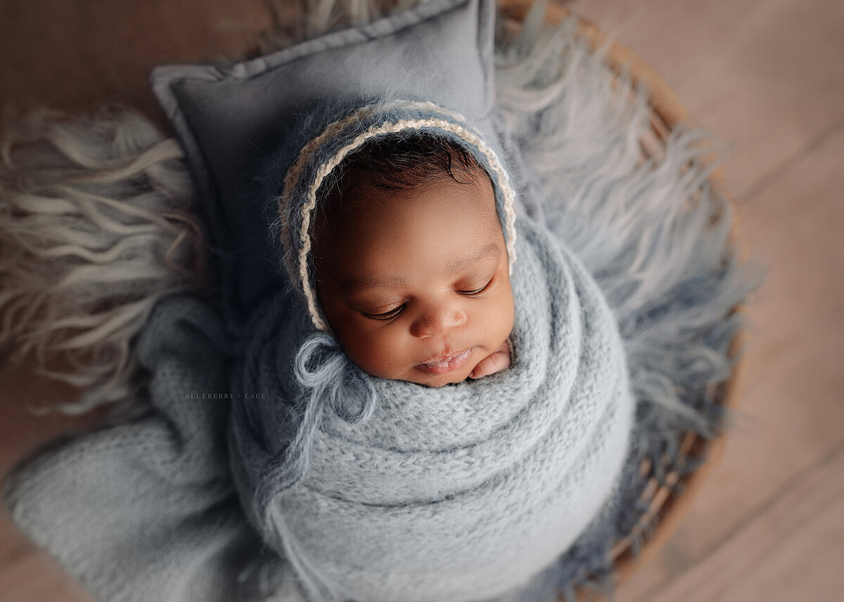 baby newborn girl wearing shades of blue for her newborn photo session swaddled so cute