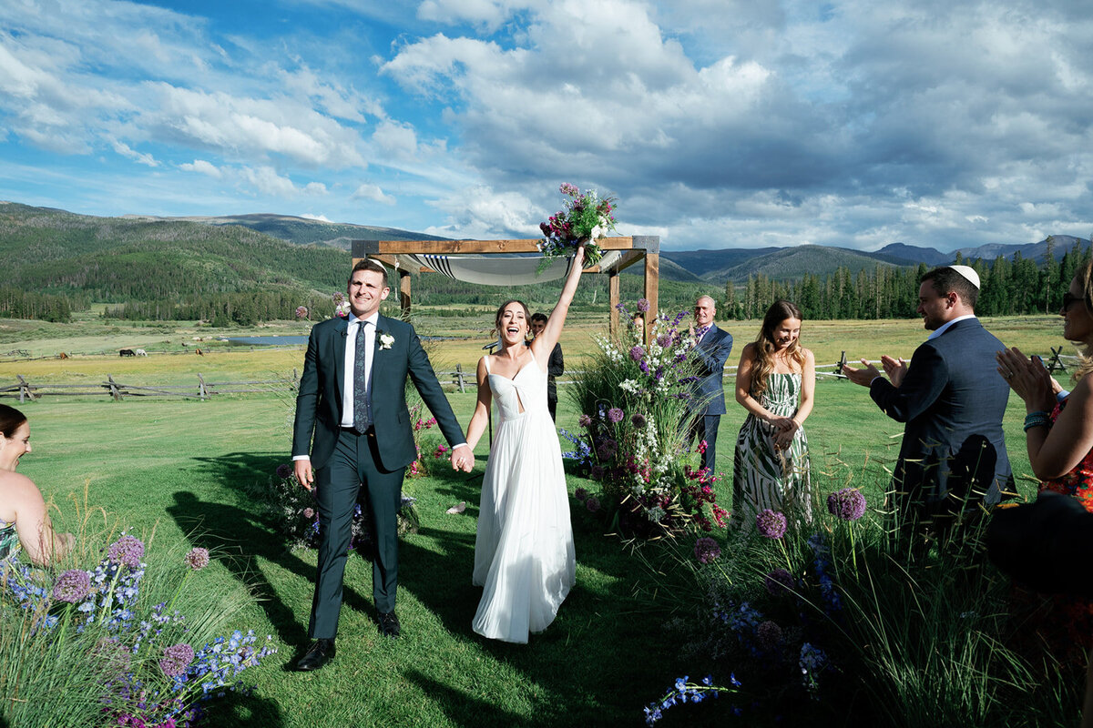 bride and groom walk back down the aisle after their Jewish ceremony at Devil's Thumb Ranch in Colorado with Jenna Wren Photography