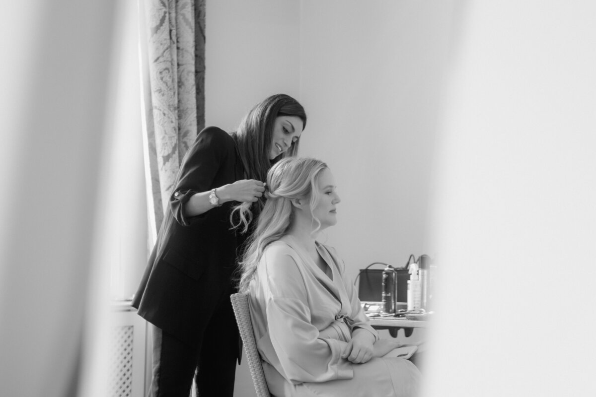 Bride gets her hair done during getting ready.