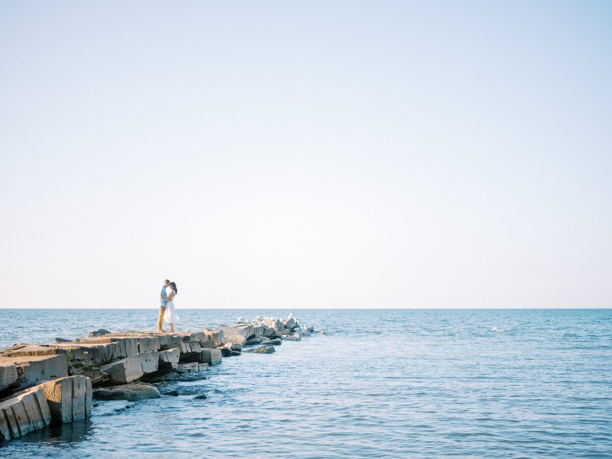 couple-kissing-on-pier-by-ocean