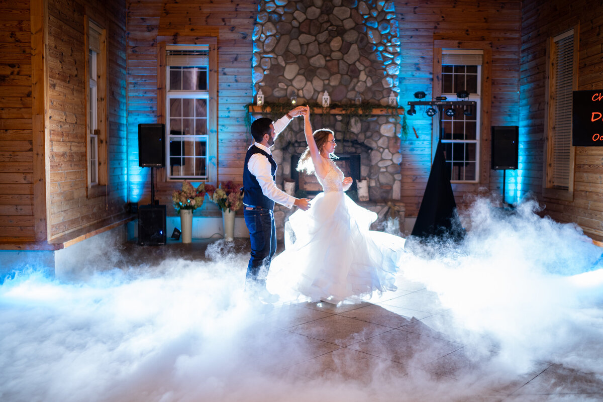 Bride and Groom dancing in the clouds backlit by flash, during their reception dance.