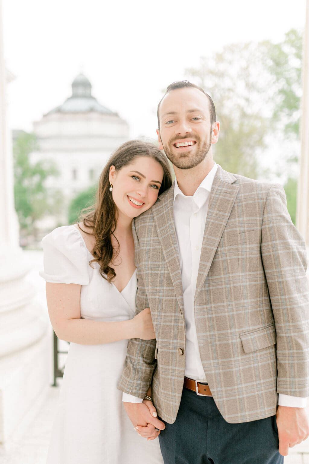 Couple looking at camera and smiling during engagement photos