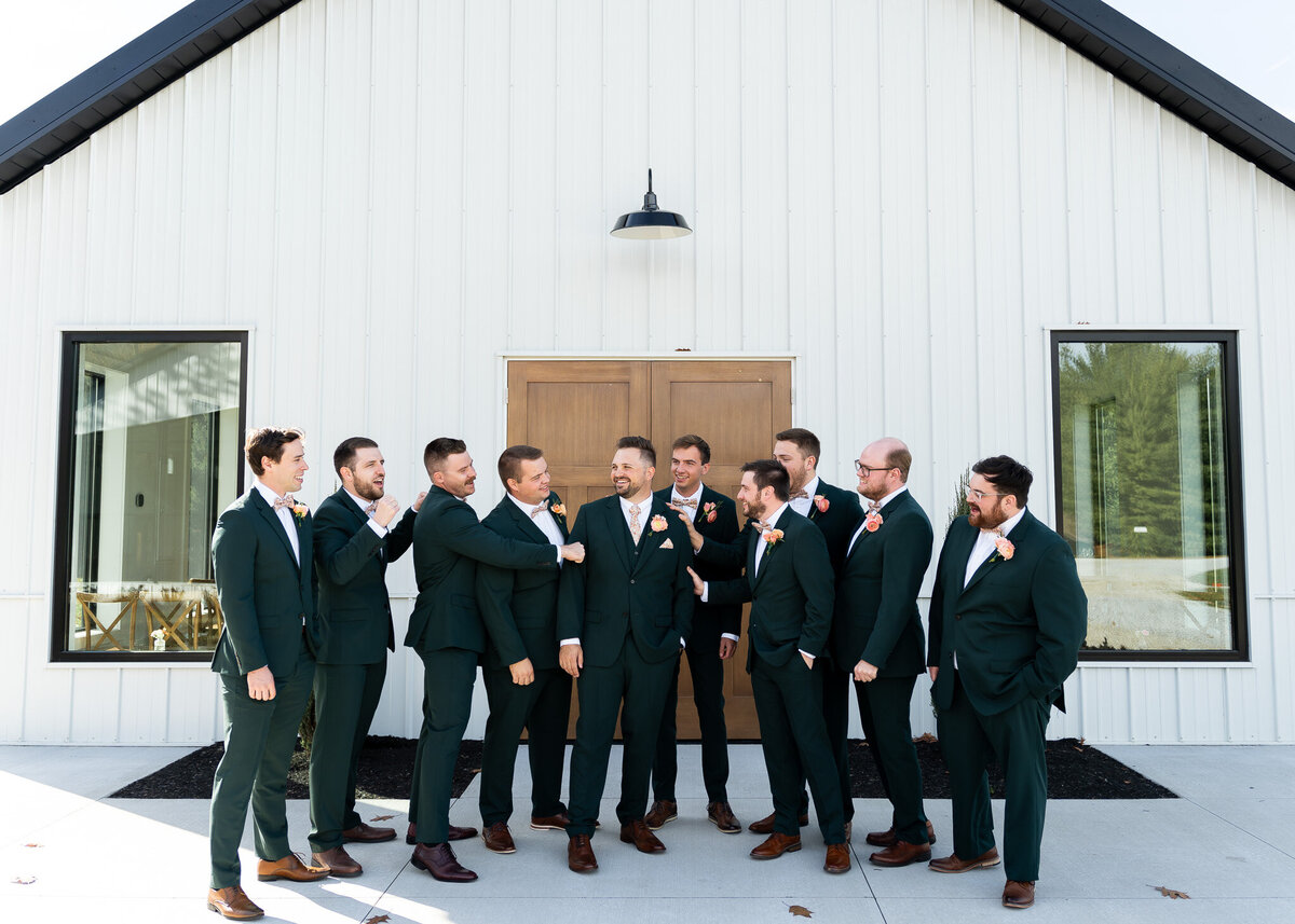 groom and groomsmen sharing candid moment prior to wedding ceremony at The Wellspring in Wooster, Ohio