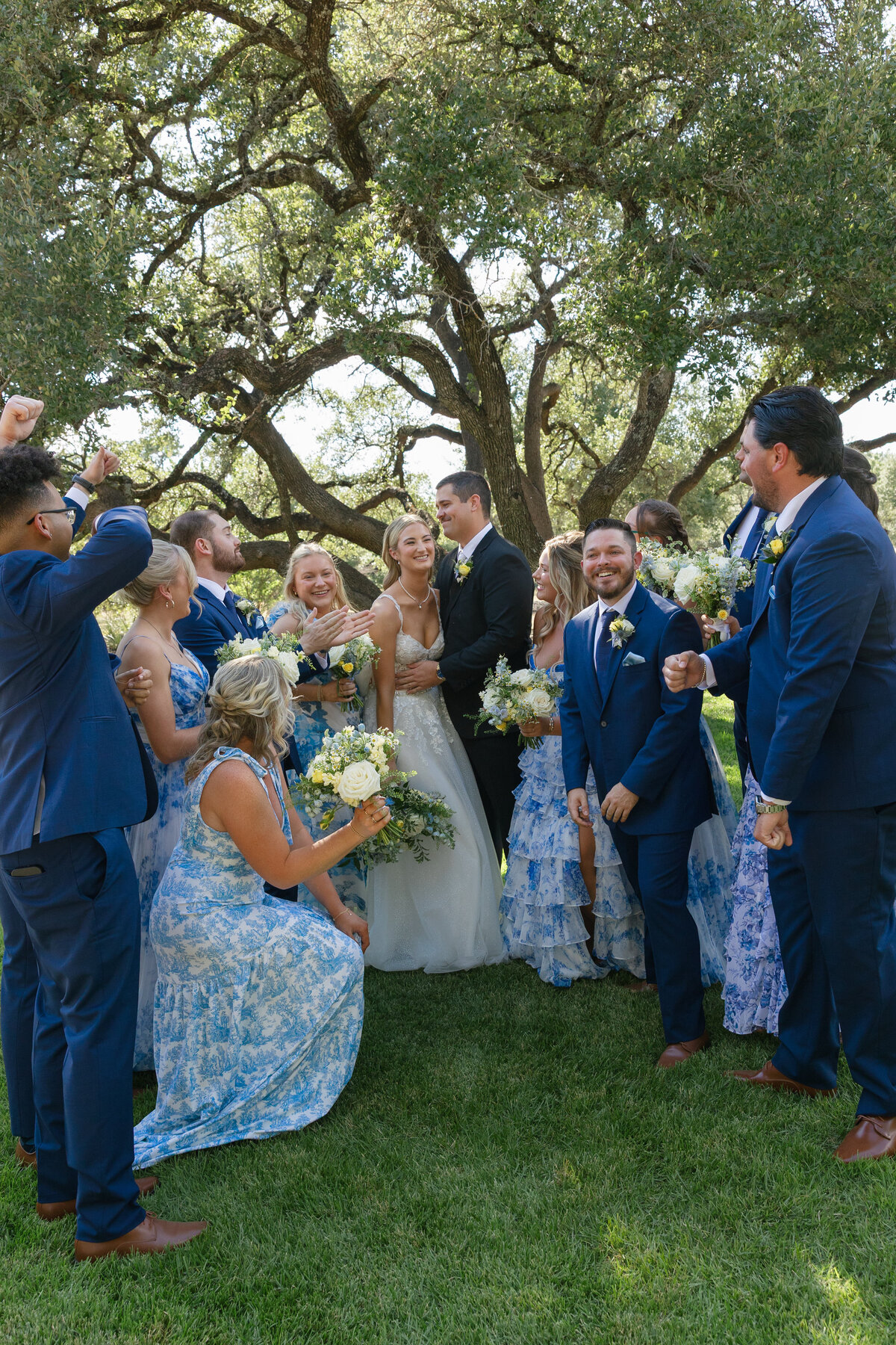 A bridal party around the bride and groom all laughing and having fun.
