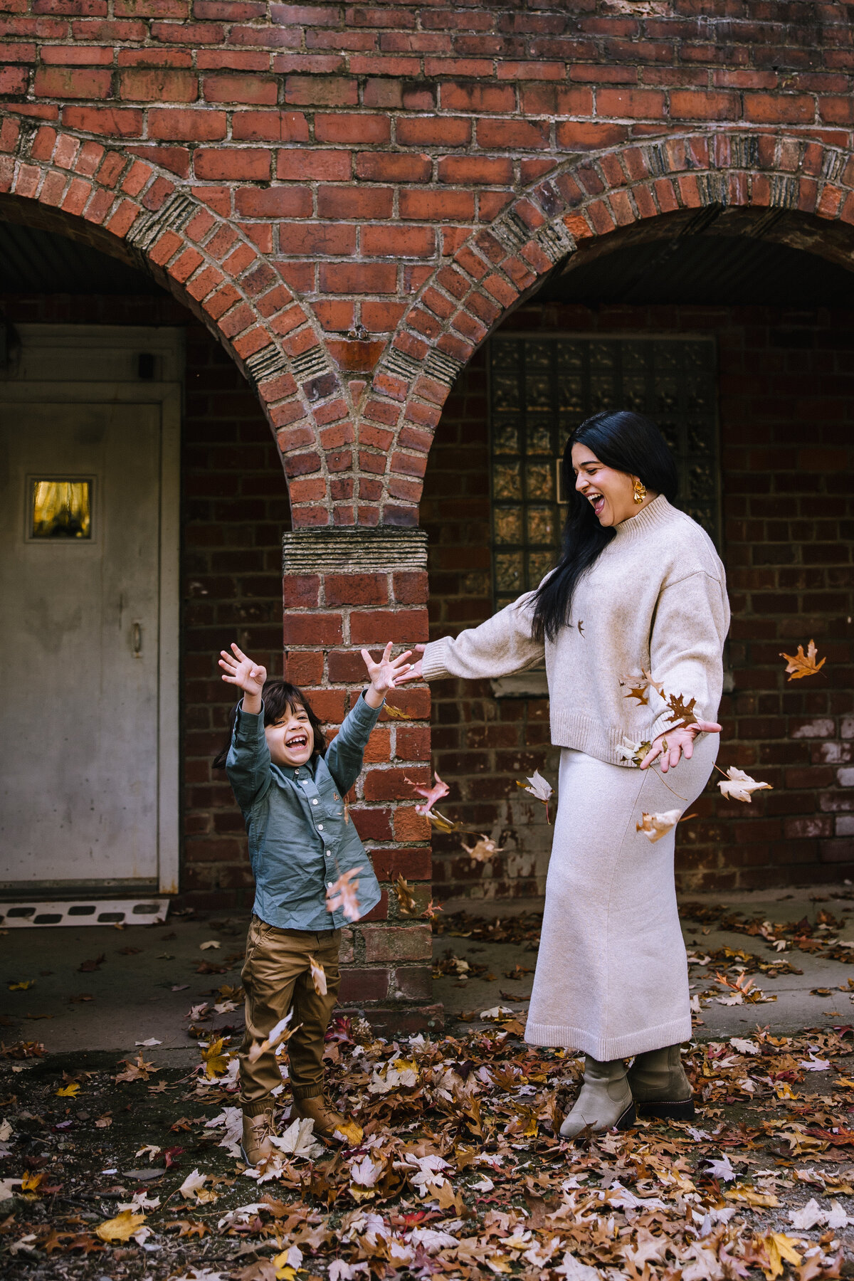 Mom and sun playing with leaves for family photos Pittsburgh.