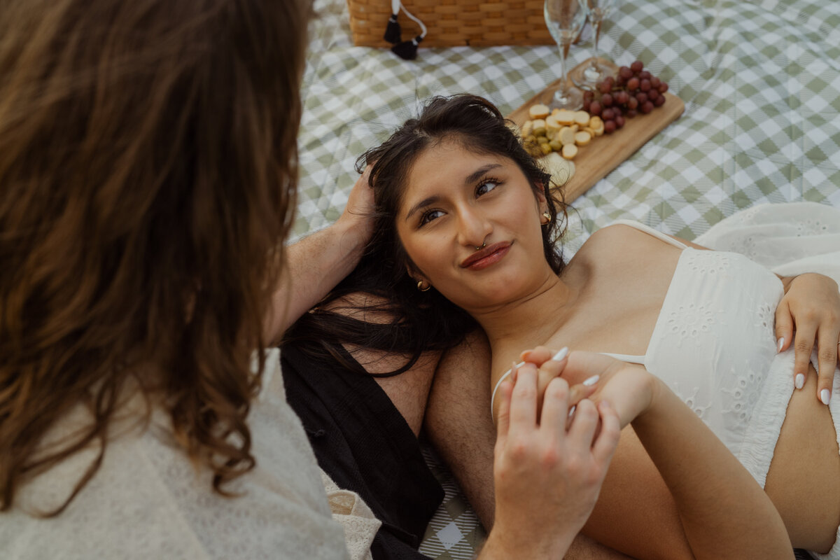 A soft, sunlit shot of the woman looking up at her partner, highlighting their connection at White Rock Lake park.