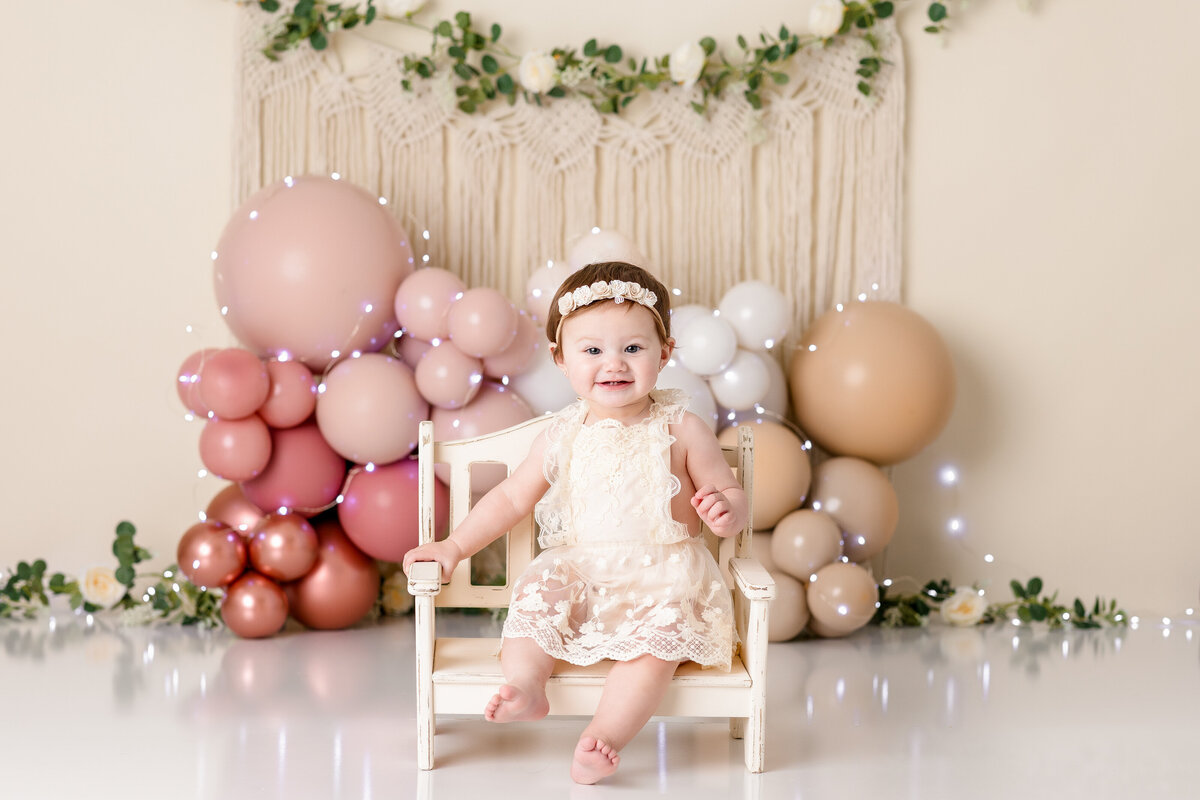One year old Tampa baby enjoying a personalized luxury cake smash session with boho themed decorations