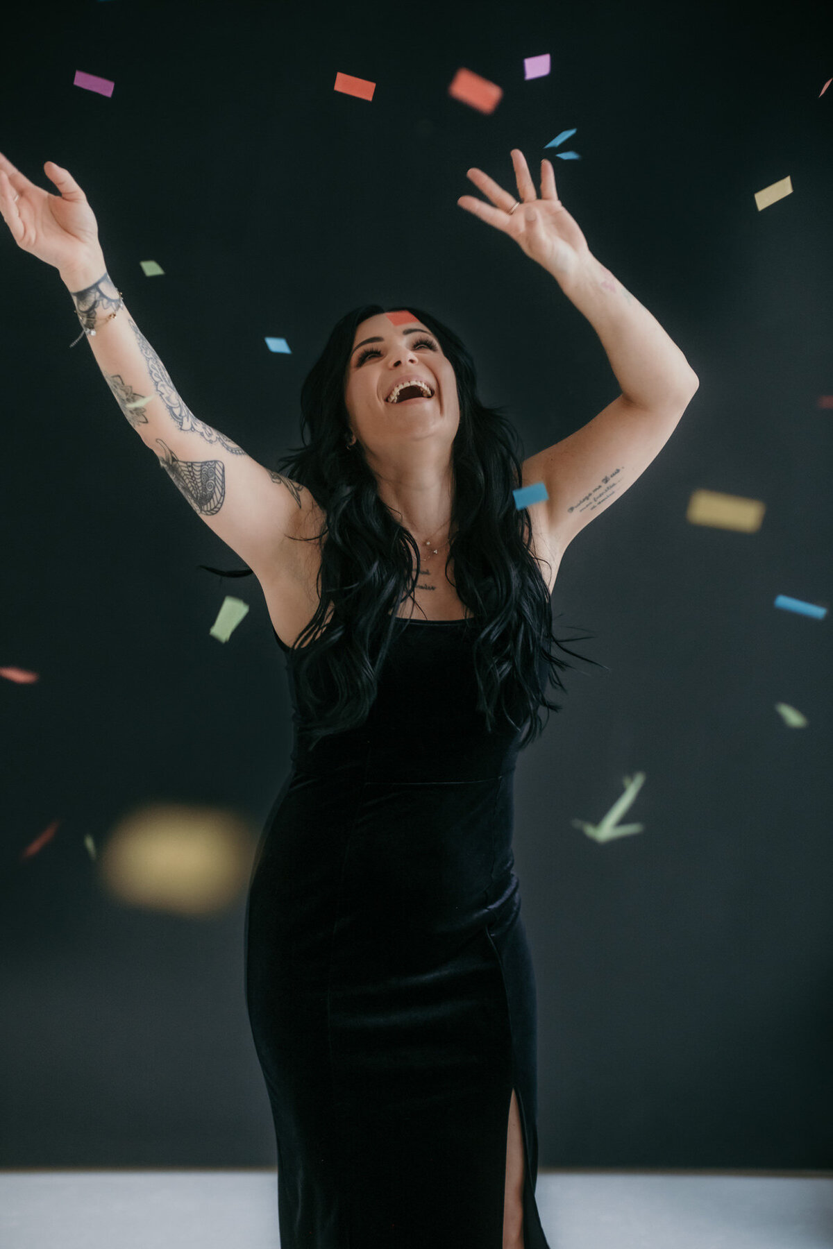 A woman dances with confetti flying trough the air.
