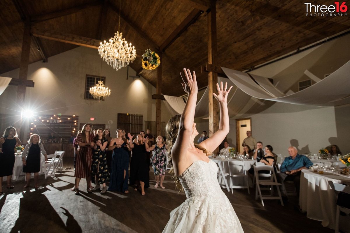 Bride tosses her bouquet to a group of women
