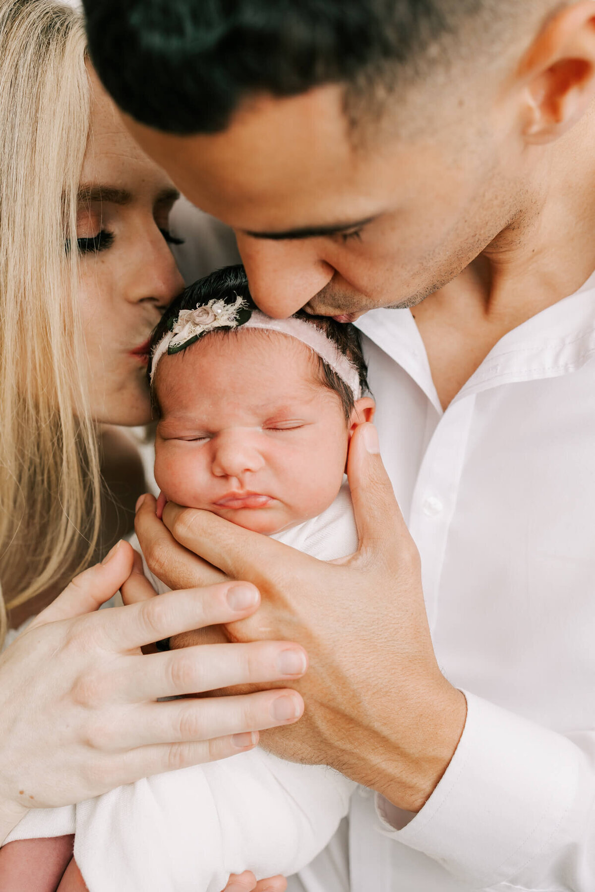 portrait of kissing newborn daughter