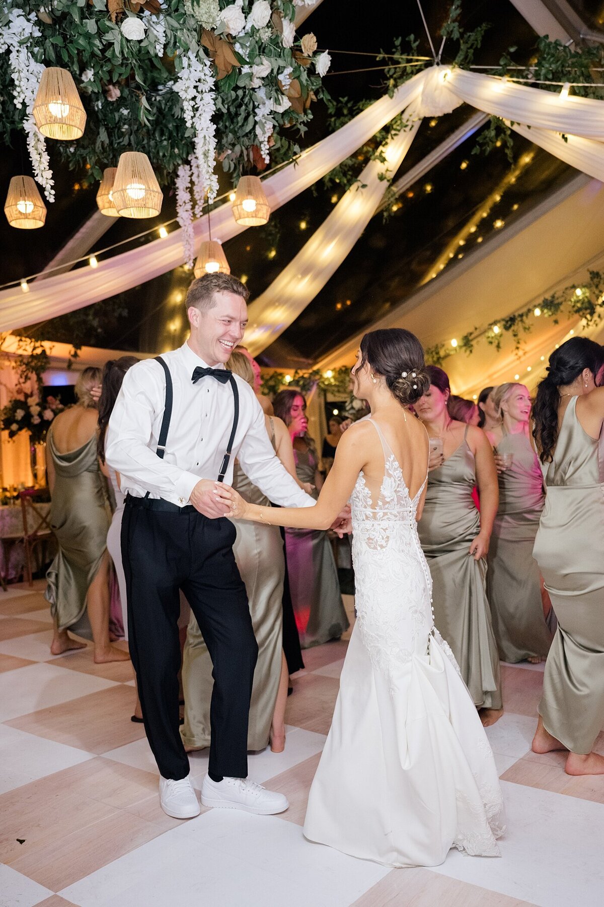 wedding reception in a white tent with string lights and greenery decorating the tent captured by Columbus wedding  photographer