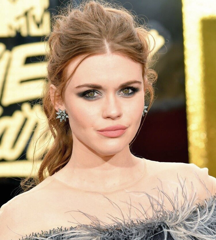 Holland Roden attending the MTV awards wearing a feather trimmed dress and a smokey eye