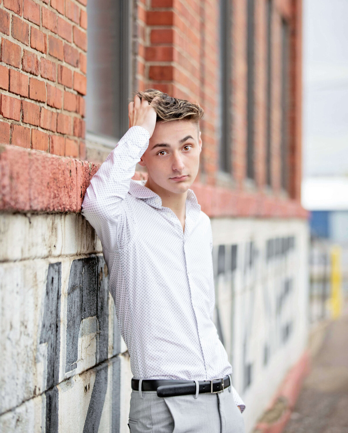 Urban senior portrait of a guy leaning into a wall in downtown Erie Pa