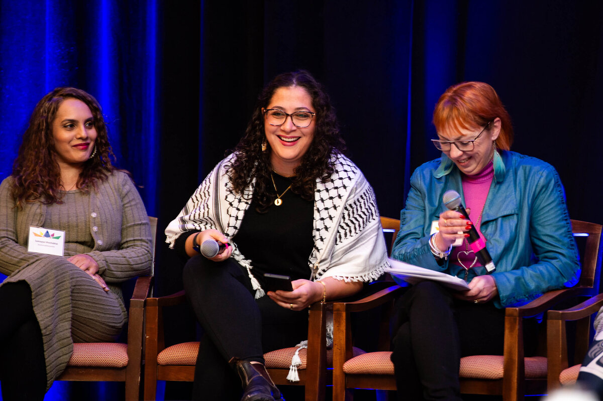 3 women in a panel discussion laughing and engaging with the audience during a 2-day corporate conference. Captured by Ottawa Event Photographer JEMMAN Photography COMMERCIAL