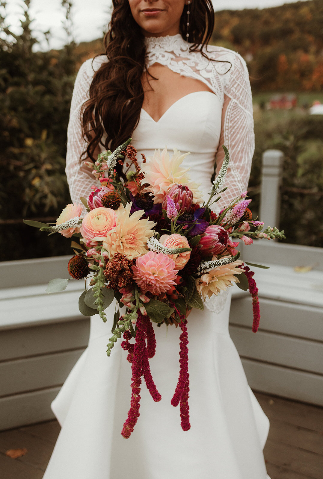 Bride holding a vibrant fall bouquet with terracotta ribbon at a winery wedding in the Hudson Valley