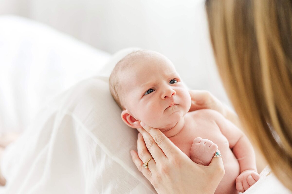 wake-newborn-closeup-laying-on-mothers-lap-bend-or