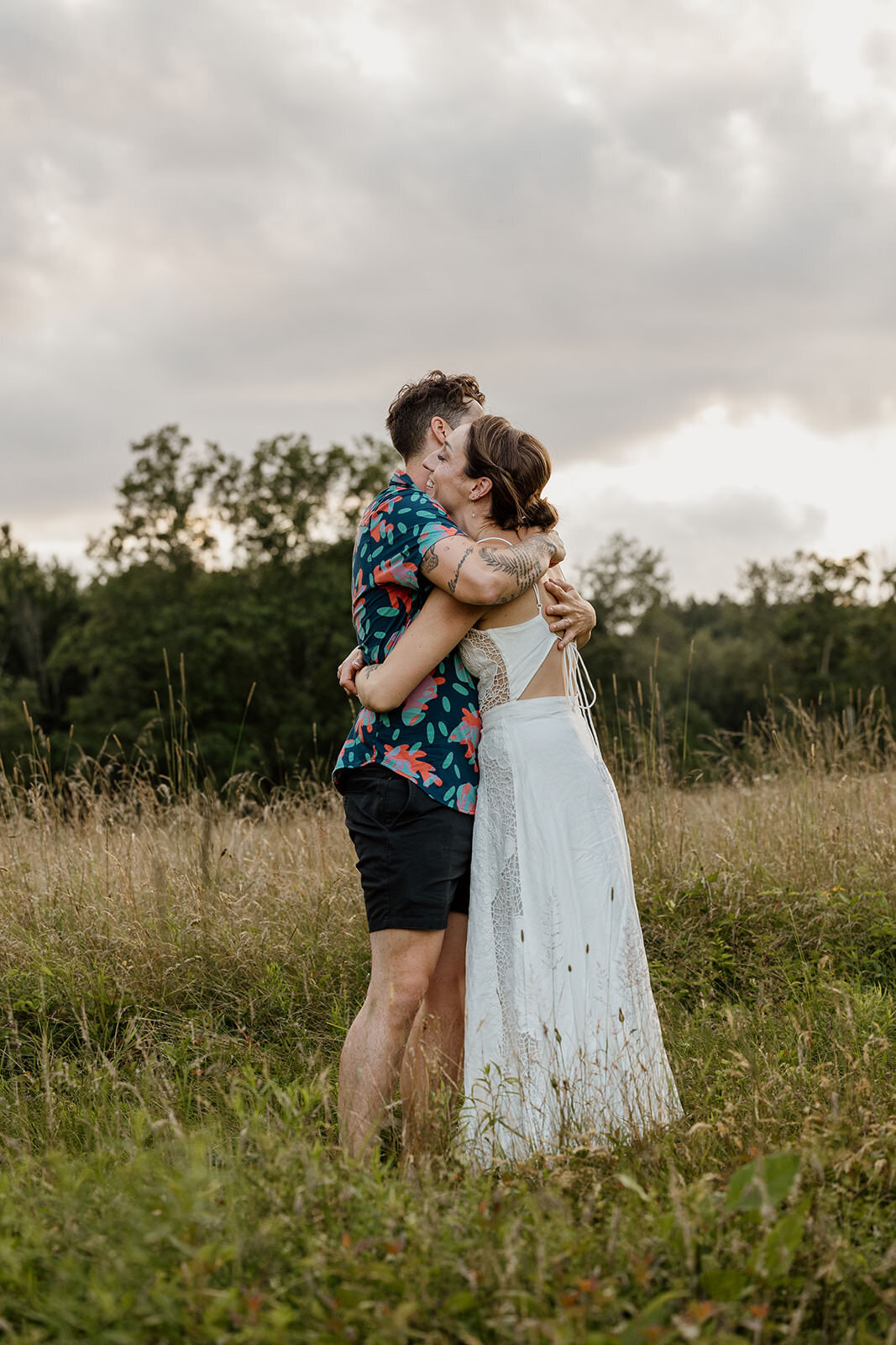 A couple hugging in a small field