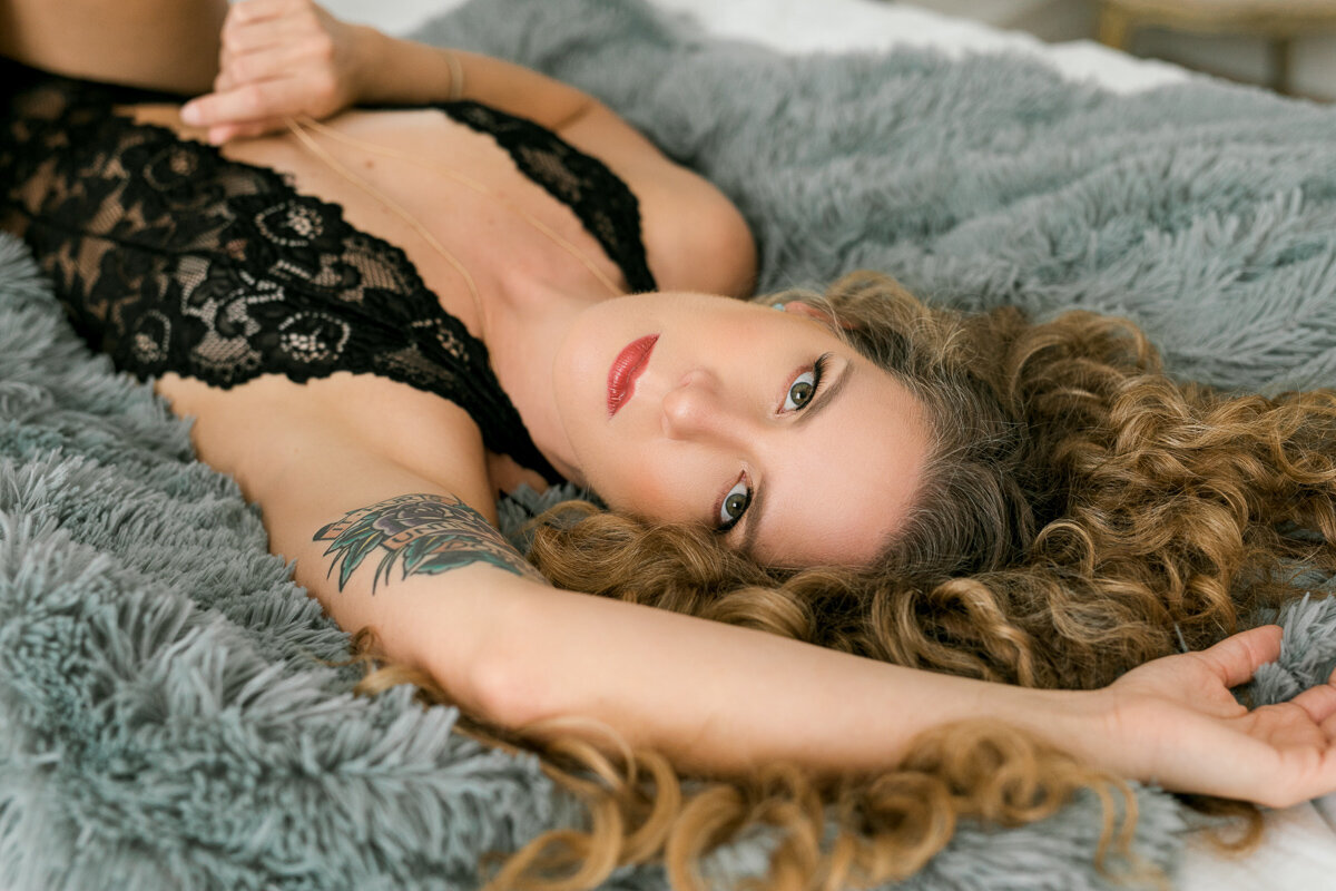 woman with curly hair laying on bed