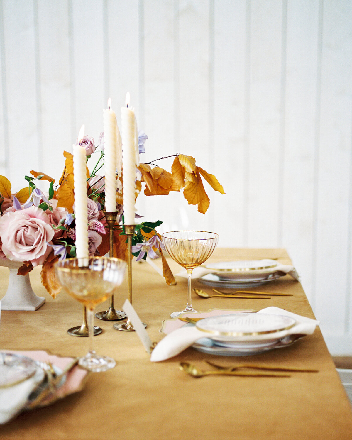 Table setting closeup with candlesticks and golden warm touches