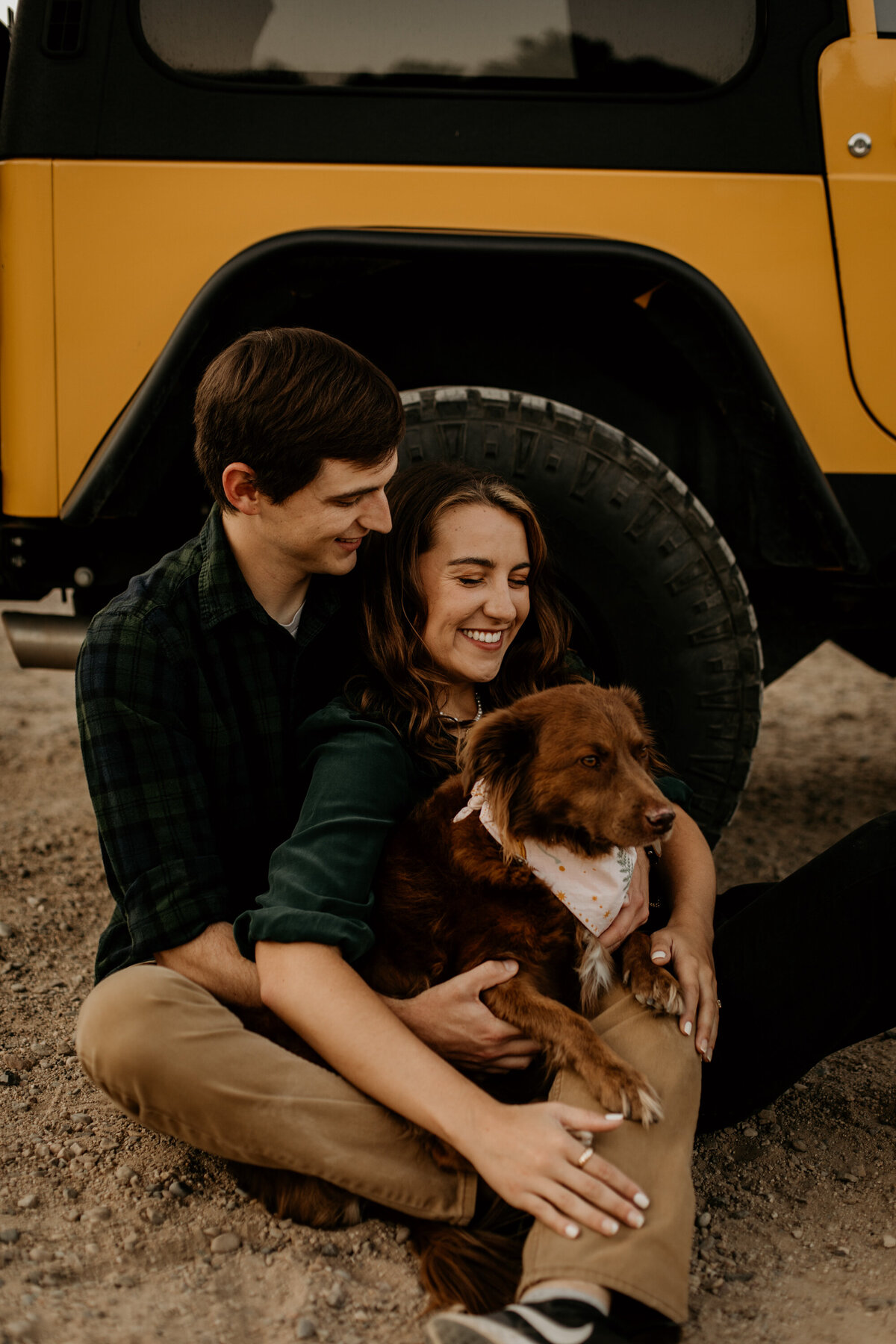 engaged couple sitting with their jeep at dog in Albuquerque New Mexico