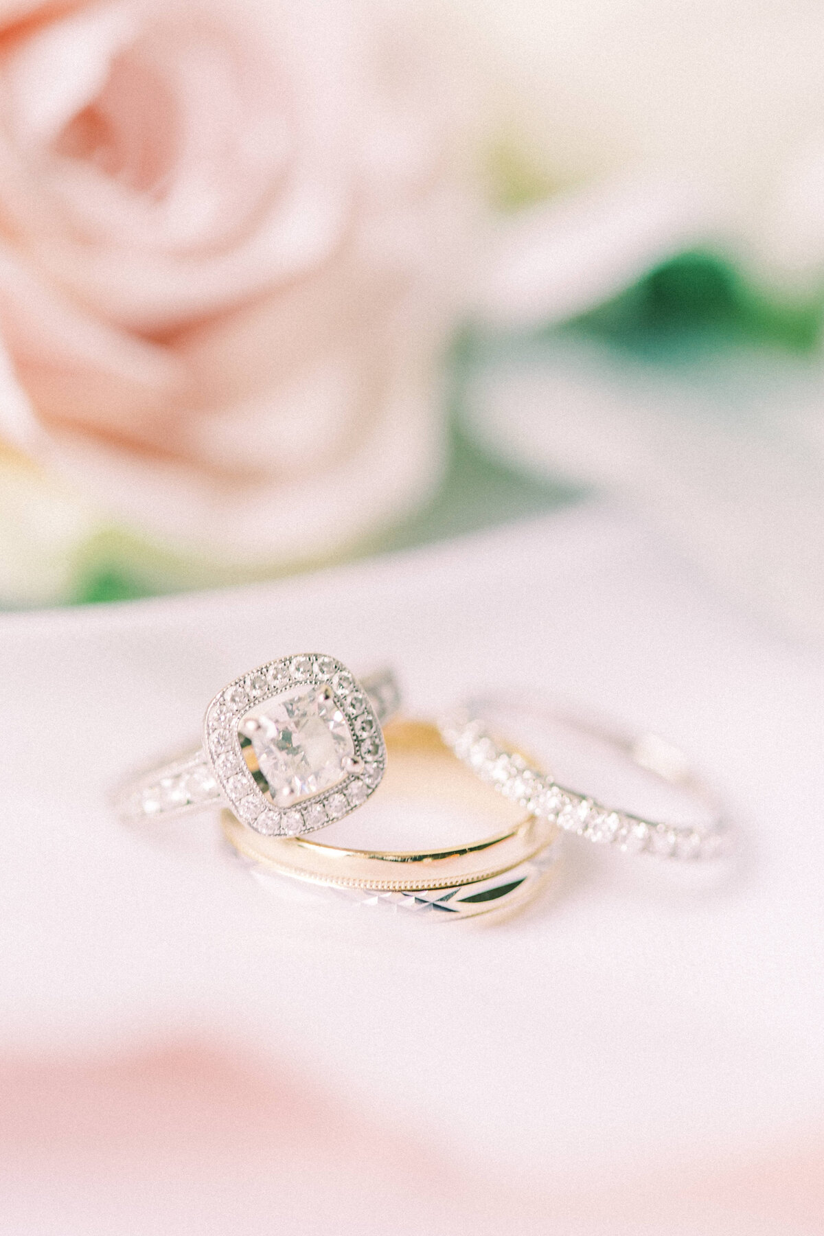 Wedding rings detail shot with blush pink florals